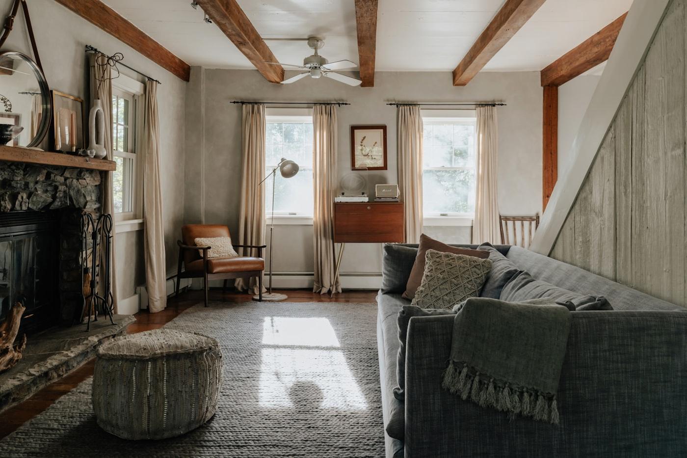 Family sitting room with exposed beams and a stone fireplace