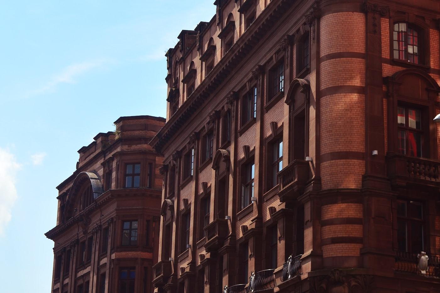 Grand red-brick Victorian mansion block against a clear sky