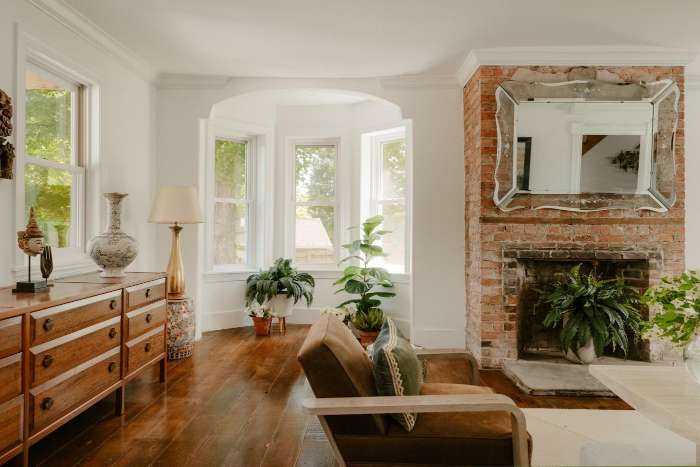 Elegant drawing room with a bay window, fireplace and gilt mirror